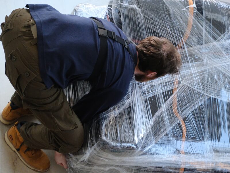 Crew wrapping furniture with stretch film